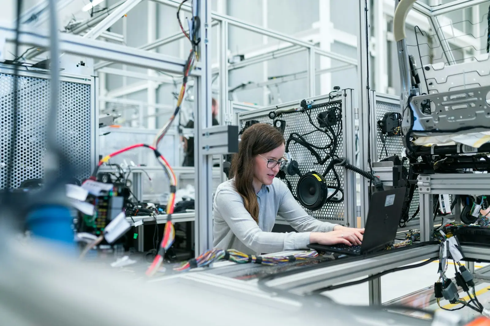 Automation engineer programming a control system beside a production machine