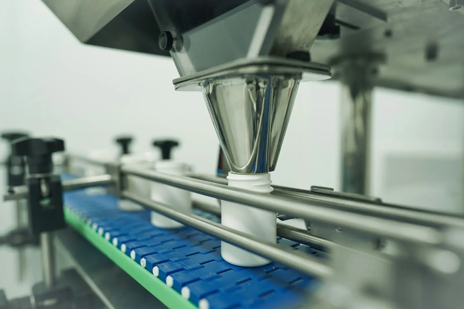 Automated filling and packaging line with containers on a conveyor